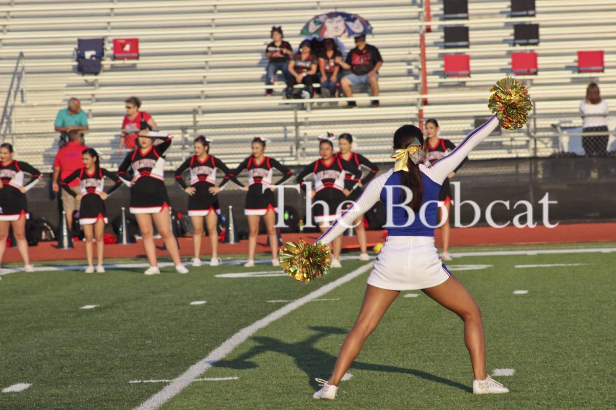 Senior Cheerleader, Fatima Torres performs the hello cheer for the Lobos fans while sporting her gold poms and bow in honor of Childhood Cancer Awareness month.