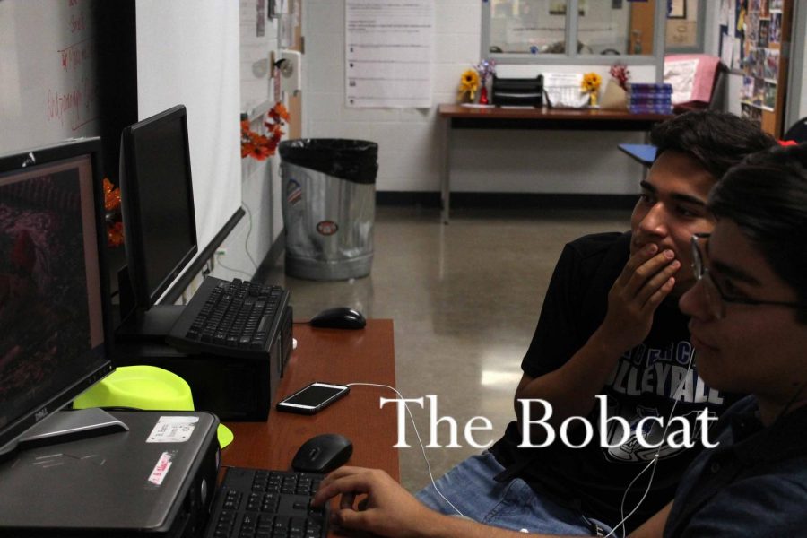 Yearbook students, Andres Salazar and Abel Sepulveda, contemplate page layouts.