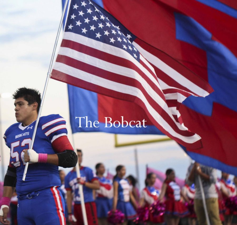 Junior, Christopher Renteria, carrying the U.S flag during the national anthem.