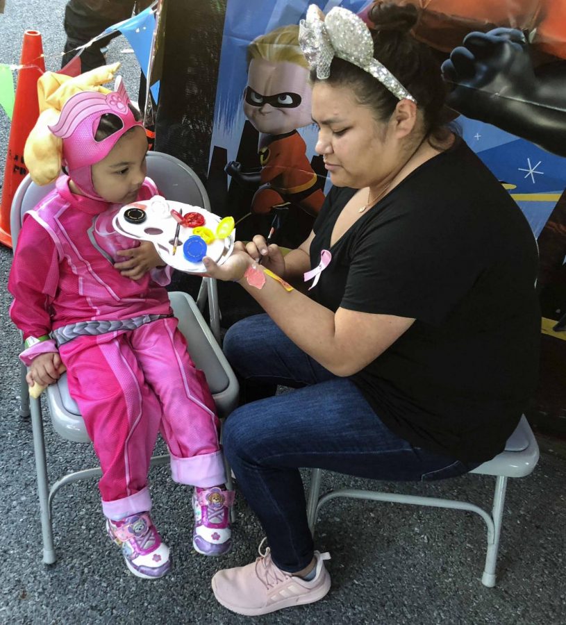 Senior,Naomi Diaz paints the face of a little girl at the event.