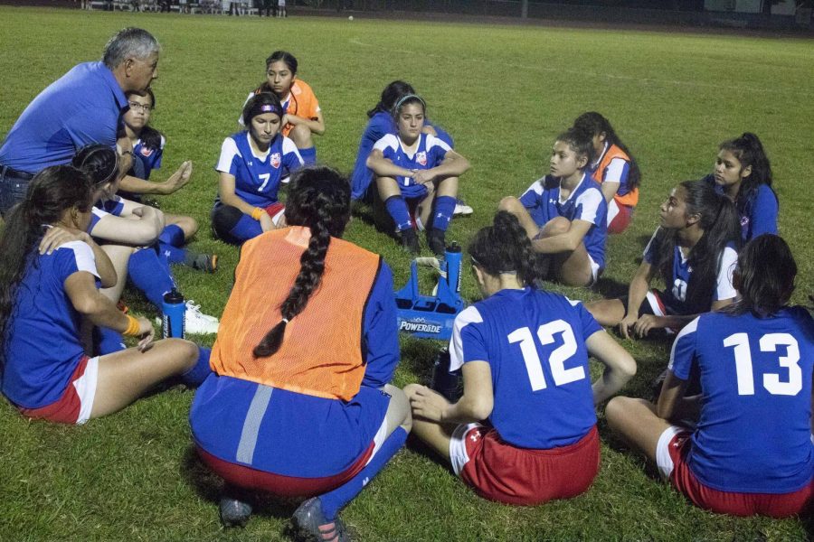 The+Varsity+Girls+Soccer+team+listens+to+some+words+of+advice+from+their+coach.