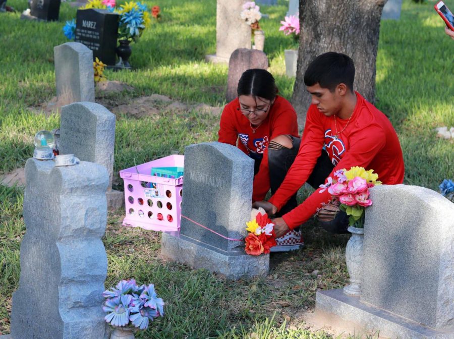 Junior Briana Lazo and Senior Demitri Galindo decorate a childs tombstone in celebration of Dia de los Muertos.