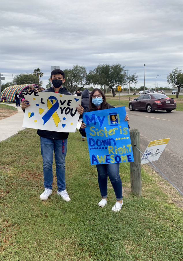 During+the+RGV+Down+Syndrome+Association+drive-by%2C+Key+Club+officer+Brandon+Sandoval+and+NHS+officer%2C+Kassandra+Sandoval+hold+posters+of+support+to+display+as+cars+drive+by.+It+was+heart+warming+to+see+all+of+the+kids+get+celebrated%2C+Kassandra+said.