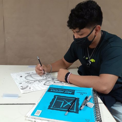 Alexis Canales, senior, works on his art piece in Ms. Villarreals AP Drawing class. Canales used graphite and torn book pages to create a still life of a few of his favorite things.  Art helps me express my feelings, Canales said.